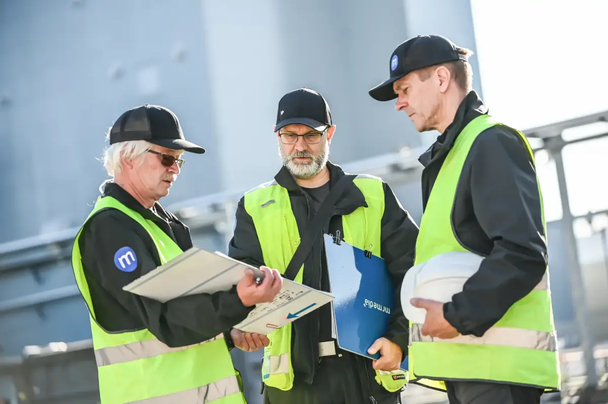 Personer i gula västar diskuterar